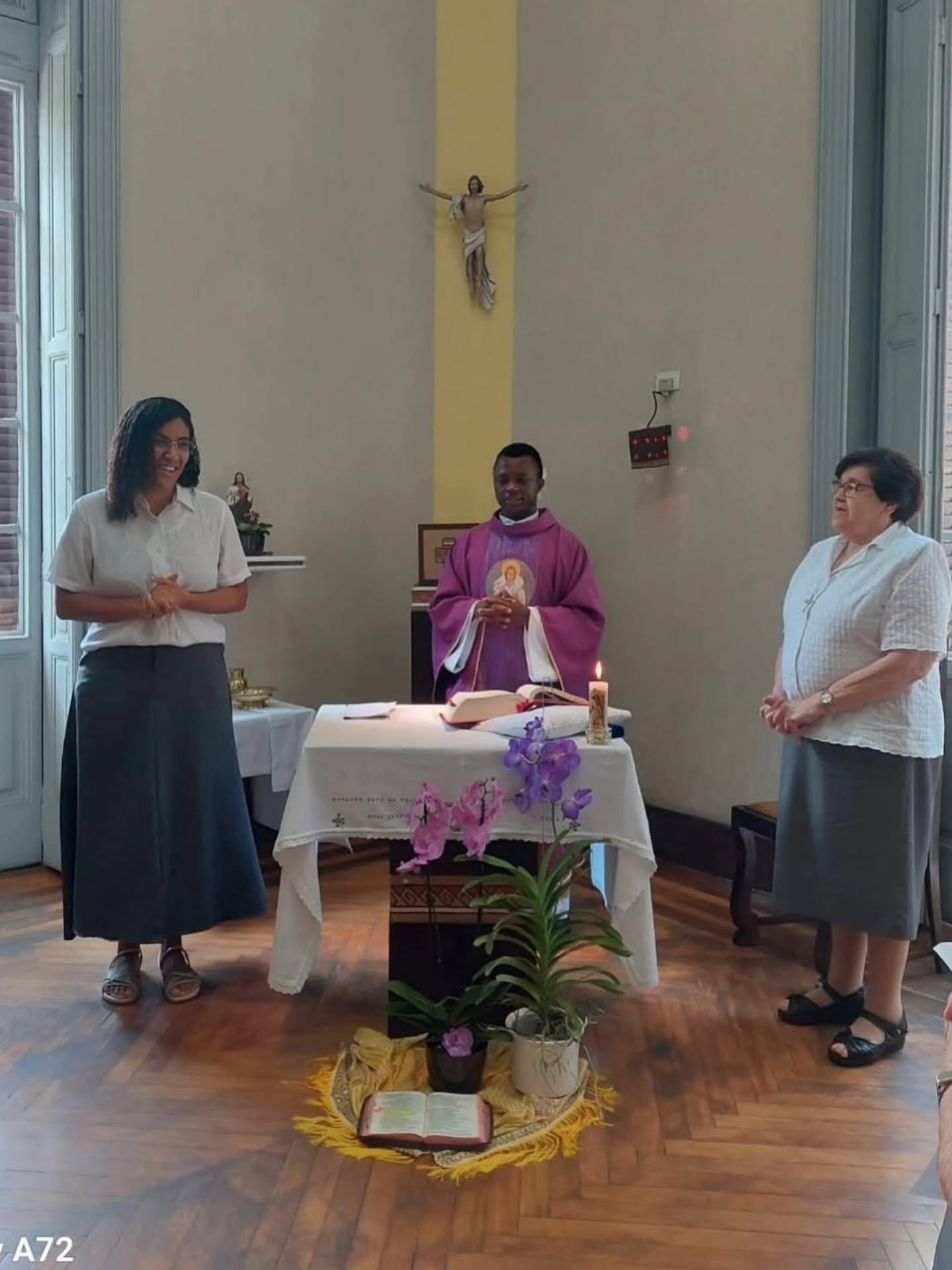 Celebração de entrada no Postulantado com a candidata, a formadora e o sacerdote diante do altar