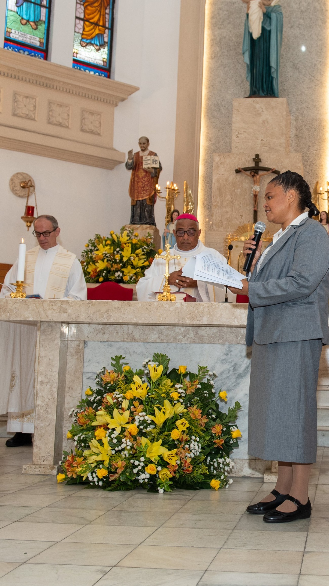 Irmã proclamando sua Profissão Perpétua diante do altar durante a celebração eucarística